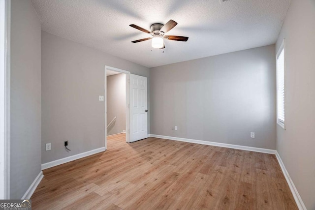 empty room featuring ceiling fan, light hardwood / wood-style floors, and a textured ceiling