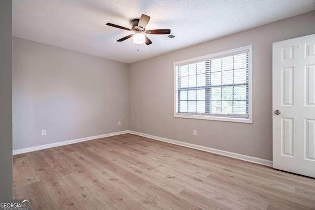 spare room featuring ceiling fan, light hardwood / wood-style floors, and a textured ceiling