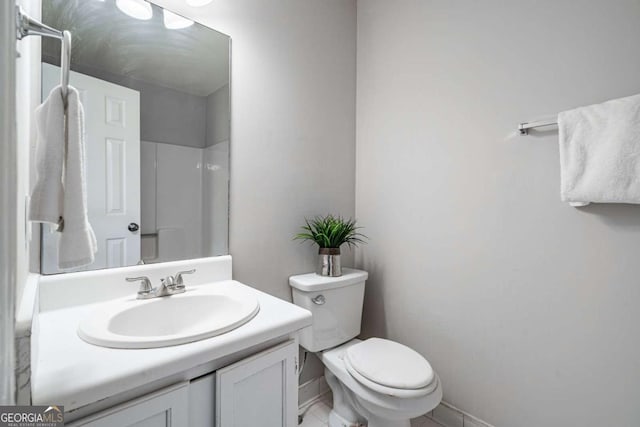 bathroom featuring a shower, vanity, and toilet