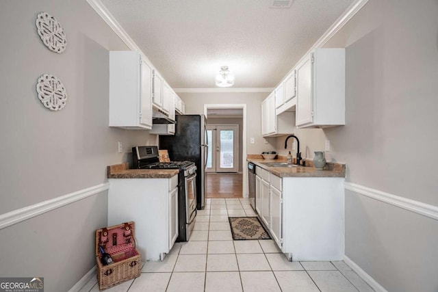 kitchen featuring sink, ornamental molding, a textured ceiling, appliances with stainless steel finishes, and white cabinetry