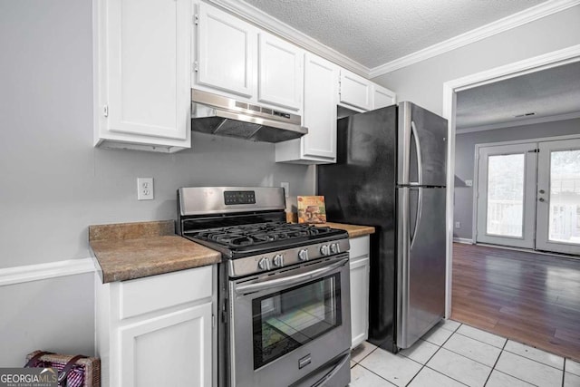 kitchen with white cabinetry, stainless steel appliances, a textured ceiling, and light wood-type flooring