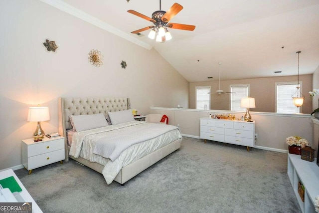 carpeted bedroom with ceiling fan, vaulted ceiling, ornamental molding, and multiple windows