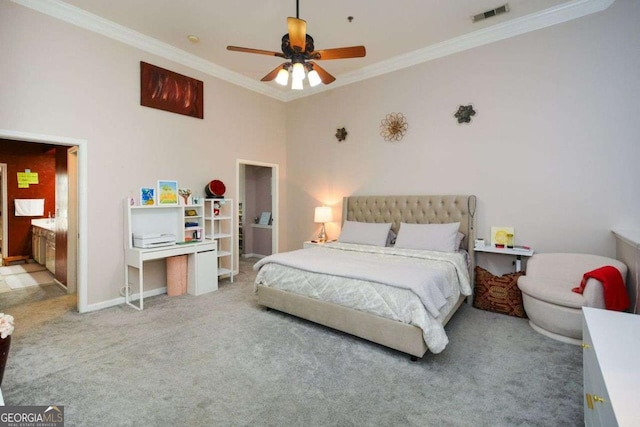 carpeted bedroom with connected bathroom, ceiling fan, and crown molding