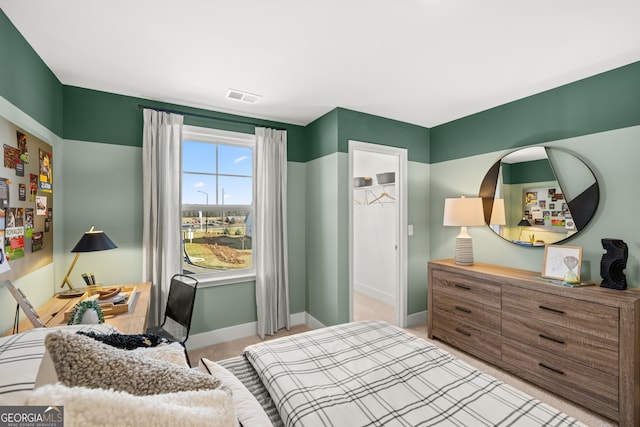 carpeted bedroom featuring a spacious closet and a closet