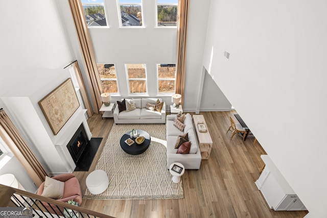 living room with hardwood / wood-style floors and a towering ceiling