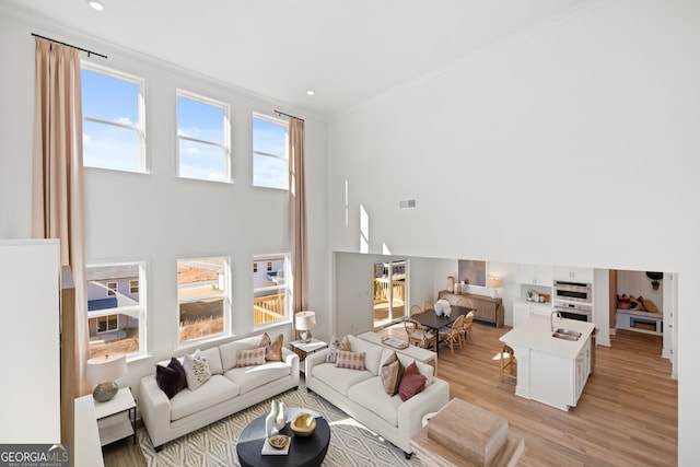 living room with light hardwood / wood-style floors and ornamental molding