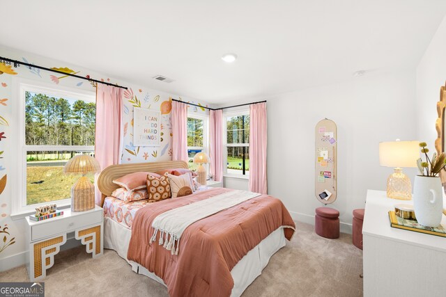 bedroom with light colored carpet and multiple windows