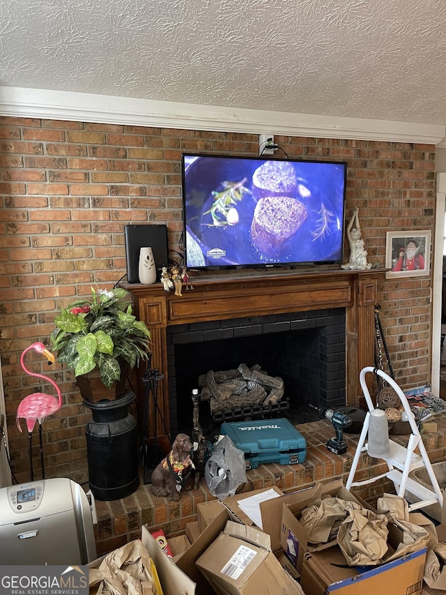 living area with a textured ceiling, brick wall, and a brick fireplace