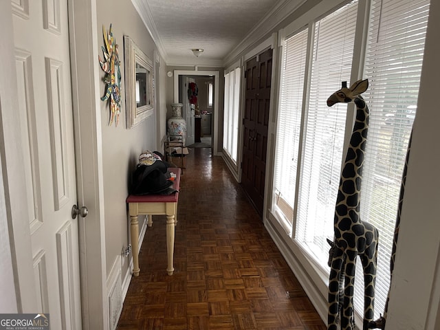 corridor with a textured ceiling, baseboards, and crown molding