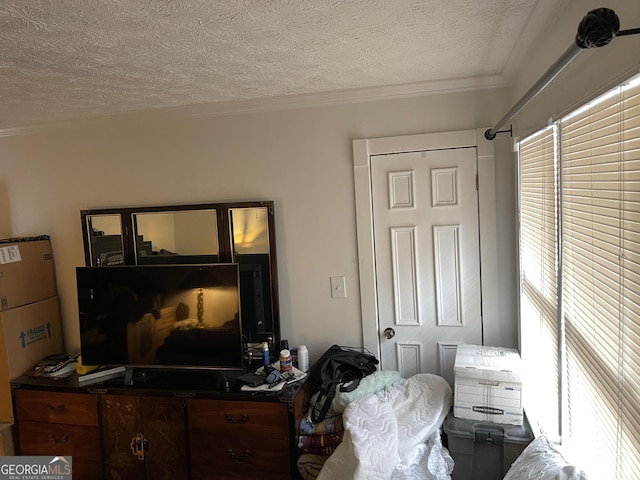 bedroom featuring a textured ceiling and ornamental molding