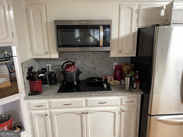 kitchen featuring tasteful backsplash, white cabinetry, and black appliances