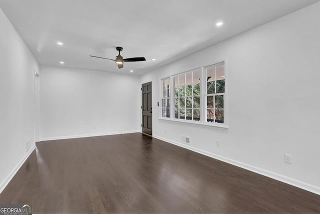 spare room with dark hardwood / wood-style floors and ceiling fan