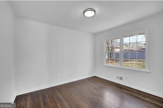 empty room with dark hardwood / wood-style floors and ornamental molding