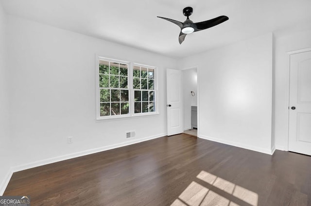 empty room with ceiling fan and dark hardwood / wood-style flooring