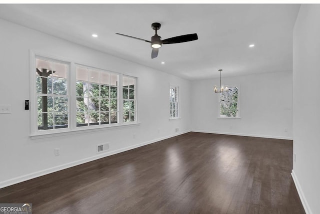 empty room featuring dark wood-type flooring and ceiling fan with notable chandelier