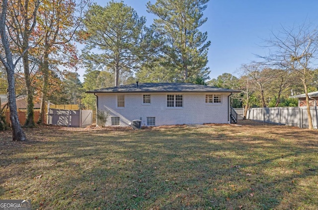 rear view of house featuring a lawn and cooling unit