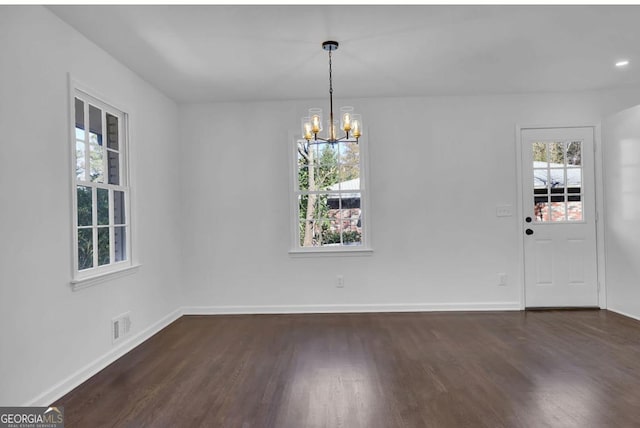 unfurnished dining area with a chandelier and dark wood-type flooring