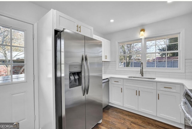 kitchen with sink, stainless steel appliances, dark hardwood / wood-style floors, backsplash, and white cabinets