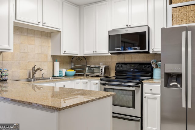 kitchen featuring light stone countertops, sink, white cabinets, and appliances with stainless steel finishes