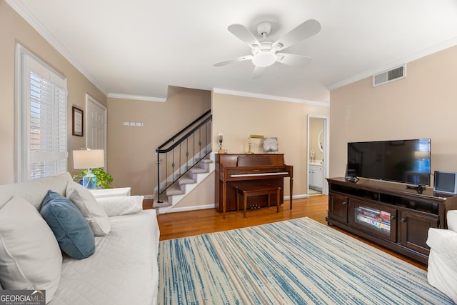 living room featuring light wood-type flooring, ceiling fan, and ornamental molding