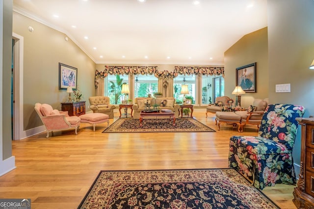 living room featuring vaulted ceiling, crown molding, and light hardwood / wood-style flooring