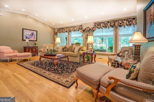 living room featuring hardwood / wood-style floors, vaulted ceiling, and ornamental molding