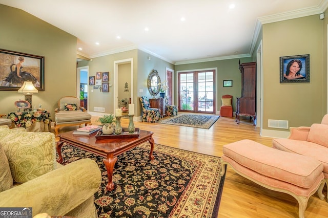 living room featuring french doors, light hardwood / wood-style floors, and ornamental molding