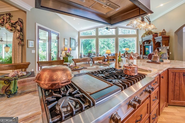 kitchen with ceiling fan, light stone countertops, crown molding, stainless steel gas stovetop, and light wood-type flooring