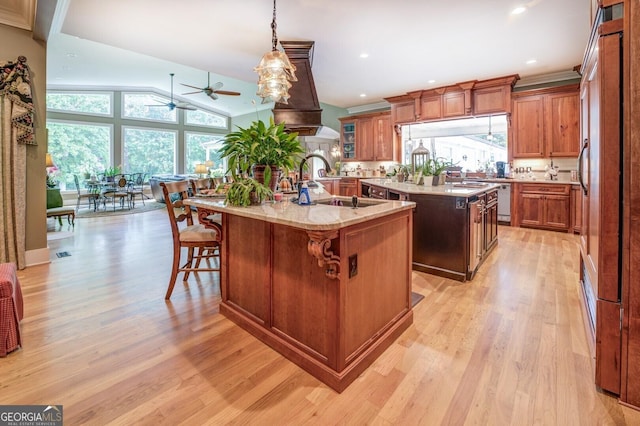 kitchen with a center island with sink, plenty of natural light, and light hardwood / wood-style flooring