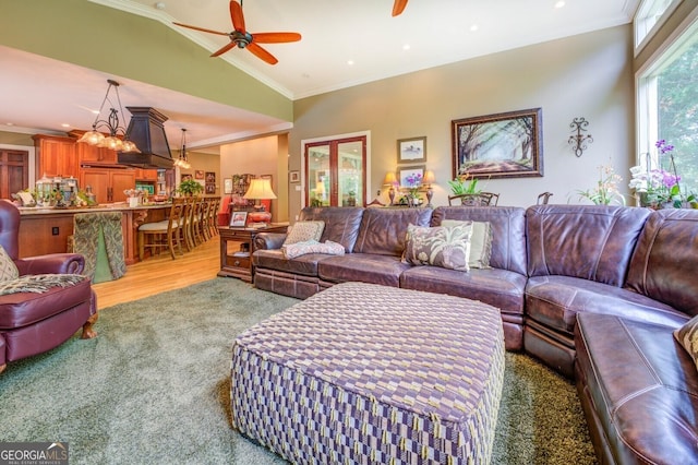 living room featuring crown molding, ceiling fan, wood-type flooring, and lofted ceiling