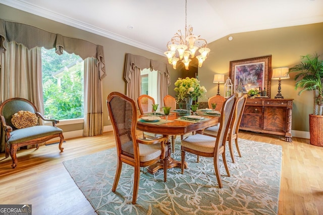 dining space featuring light hardwood / wood-style flooring, ornamental molding, vaulted ceiling, and a notable chandelier