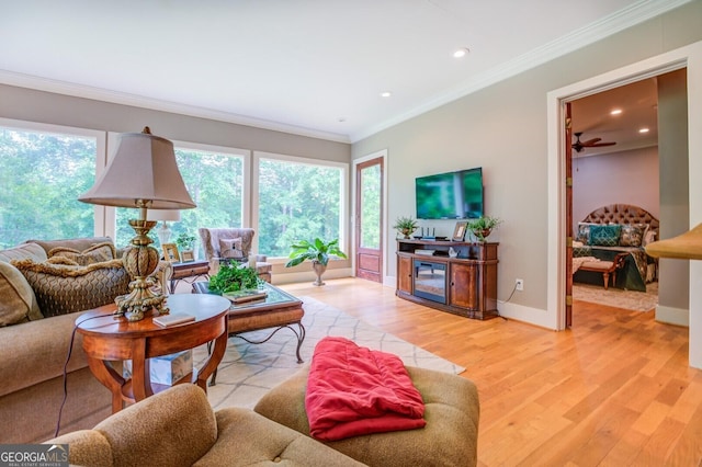 living room with light hardwood / wood-style flooring, a wealth of natural light, crown molding, and ceiling fan