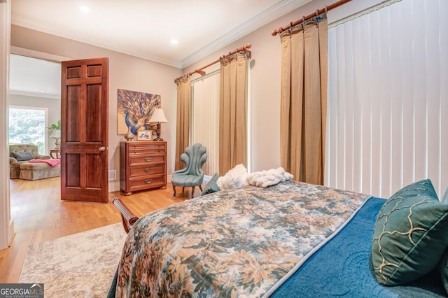 bedroom featuring light wood-type flooring and crown molding