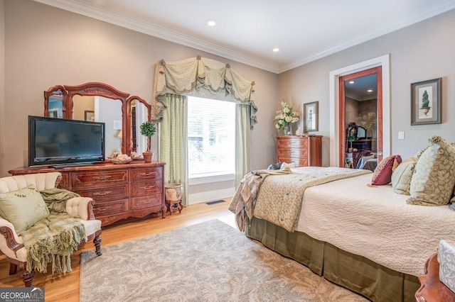 bedroom featuring light hardwood / wood-style flooring and crown molding