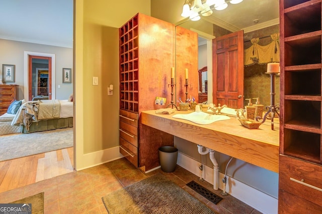 bathroom featuring sink, wood-type flooring, and crown molding