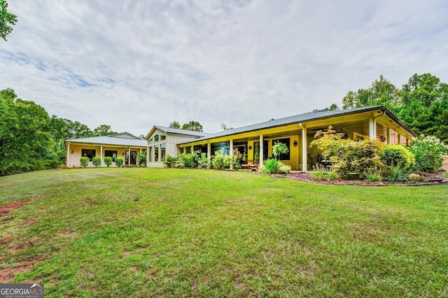 rear view of property with a yard