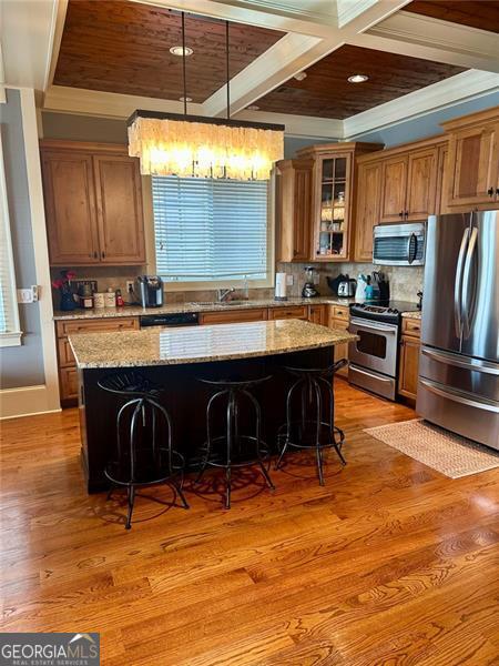 kitchen featuring light stone countertops, a breakfast bar, a kitchen island, and stainless steel appliances