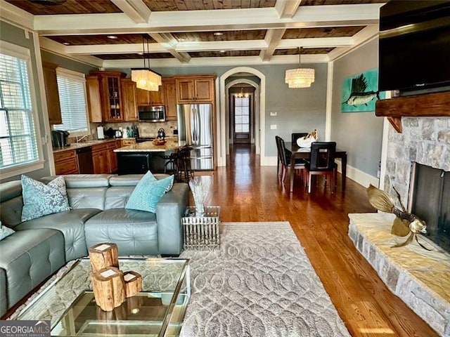 living room with beam ceiling, dark hardwood / wood-style flooring, and a healthy amount of sunlight