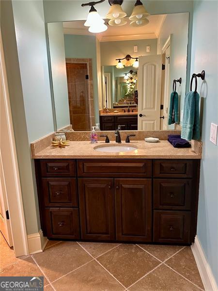 bathroom with tile patterned floors, vanity, and ornamental molding