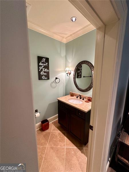 bathroom featuring tile patterned floors, crown molding, and vanity