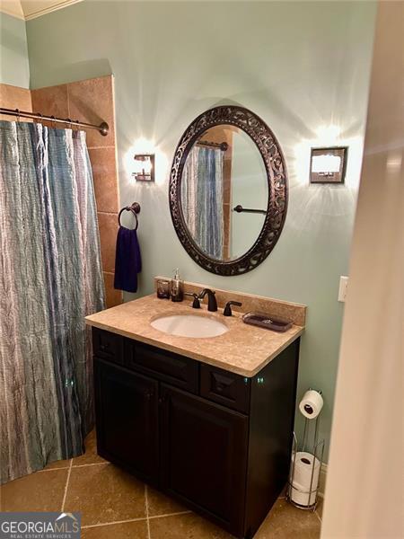 bathroom featuring tile patterned flooring, vanity, and a shower with shower curtain