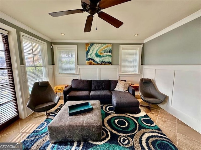 living room featuring light tile patterned floors, ceiling fan, and crown molding