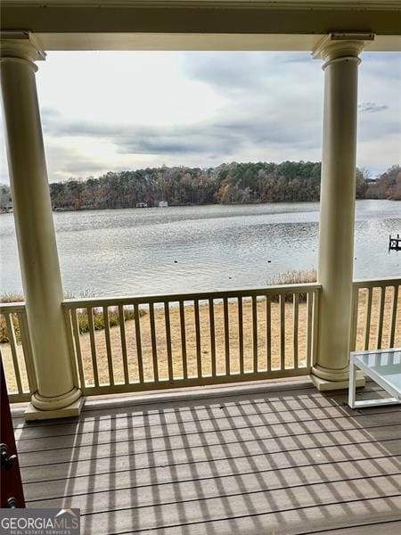 deck with a porch and a water view