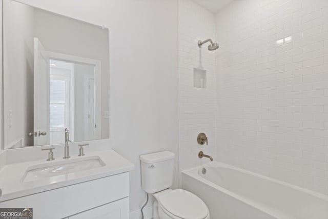 full bathroom with tiled shower / bath, vanity, and toilet