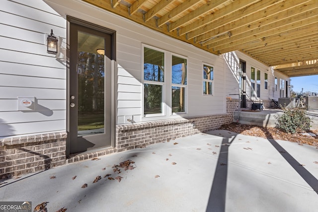 entrance to property with cooling unit and a patio area