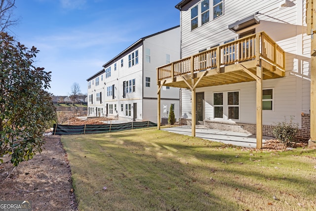 back of property featuring a yard, a patio, and a deck