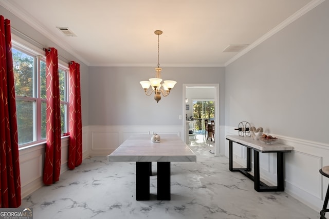 dining space with ornamental molding and an inviting chandelier