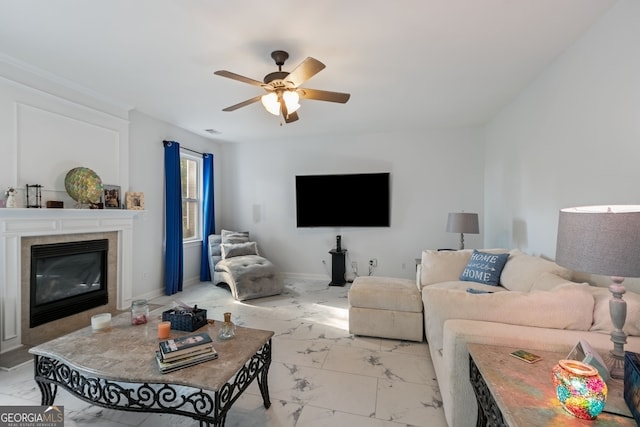 living room with ceiling fan and a fireplace