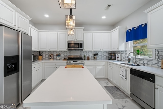 kitchen with white cabinetry, sink, a center island, and appliances with stainless steel finishes