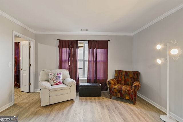 sitting room with light hardwood / wood-style floors and crown molding